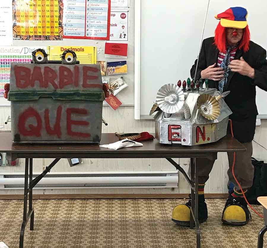 Dewit with Barbie Que and his “brain scanner,” two props he created to make his fire safety presentations both memorable and fun