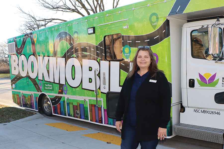 Bookmobile branch manager Pam Palcat stands beside the South Interlake Regional Library’s newly wrapped, brightly coloured Bookmobile as it returns to the road for the new school year