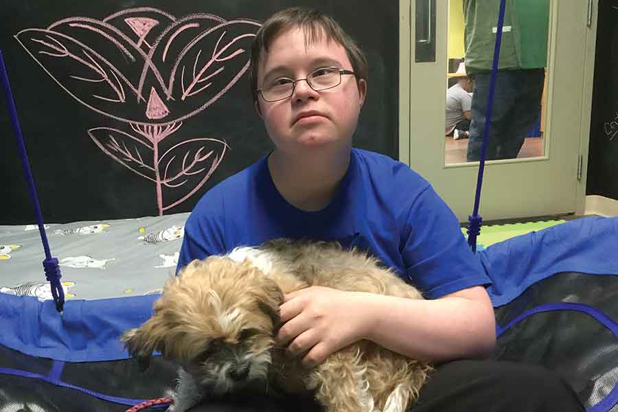 Jeremy, a Hearthstone day program participant, enjoys spending time with dogs through the Gentle Pets program. Hearthstone is seeking a volunteer to help run the program