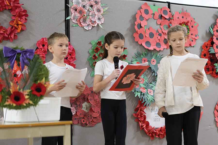 Grade 3 students Austin Olson, Nora Williams and Maren Van Hussen take turns reading during École R.W. Bobby Bend School’s Remembrance Day service