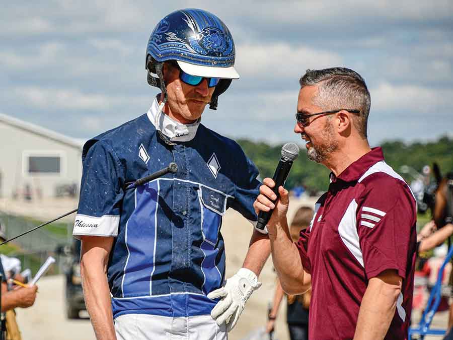 Pro harness racing driver Daryl Thiessen fields questions trackside after a race on the Ontario circuit
