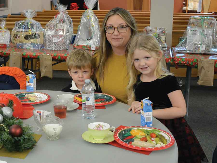 Brittany, Austin and Abby Moffatt enjoy the Christmas atmosphere at Christ Church’s annual Christmas Tea and Bake Sale on Nov. 29. Below, Guests enjoyed lunch; Winston McLeod and Gary Elbers greet community members as they entered the church; Bill Shead with some of the treats available at the bake sale
