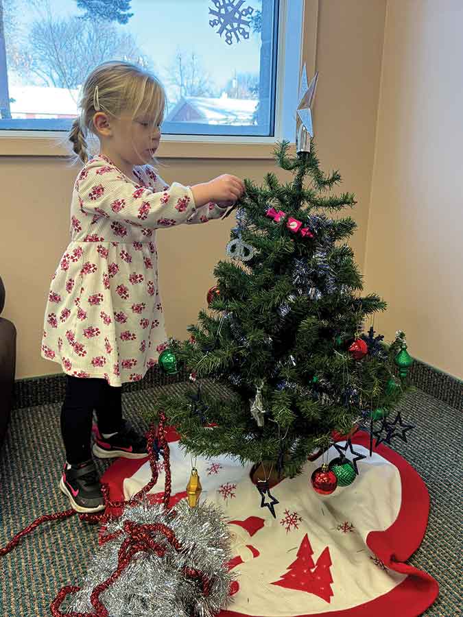 Haley, 2, decorates the Christmas tree at AAFRC’s Celebrate the Season bash Friday
