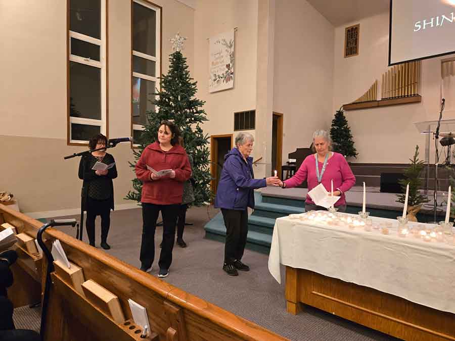 Family members read and light candles at the regional palliative care memorial service