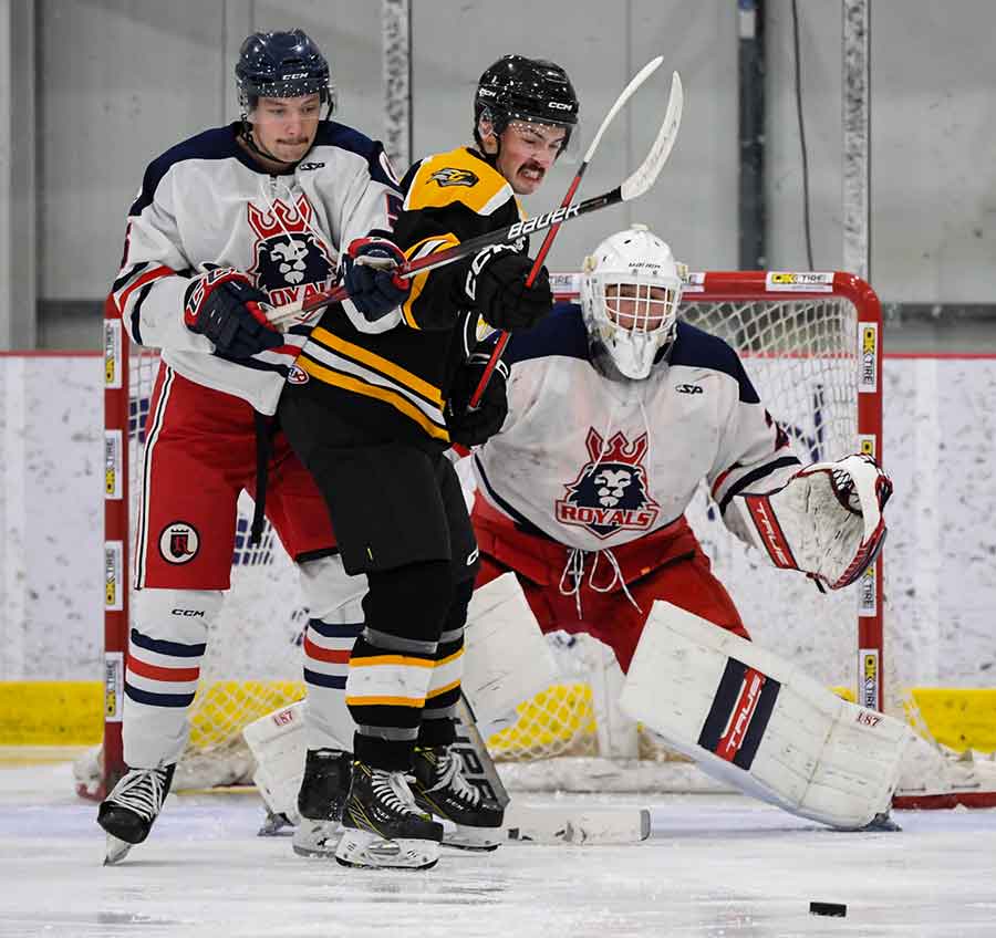 Royals defenseman Mike Heppner tries to keep a Carman player from deflecting a shot in front of goalie Matt Thiessen