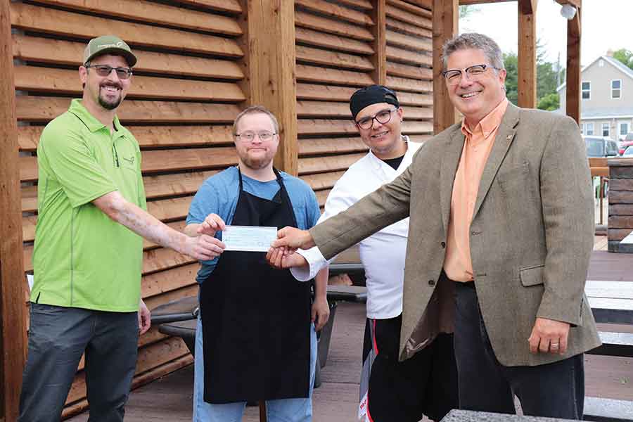 Jim Simon and clients (right) at Stonewall’s Something Beautiful Cafe were recipients of a Build Interlake Growth grant. Eugene Zalevich (left) presented the grant