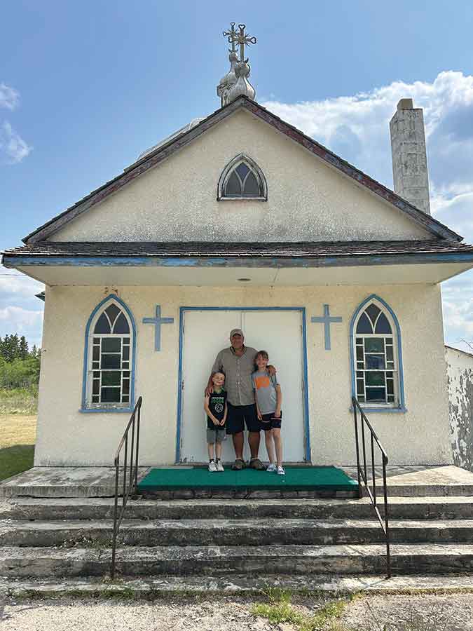 Steve Marykuca, with his kids, is the caretaker of St. Nicholas Ukrainian Catholic Church and cemetery in Poplarfield