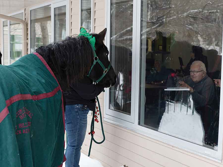 Rosewood Lodge resident Jarvis Baryliuk waves to Iris through the window