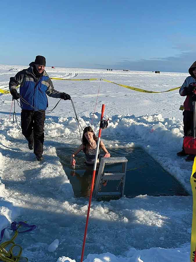 Kennedy Gunnink plunges into the icy waters of Lake Winnipeg