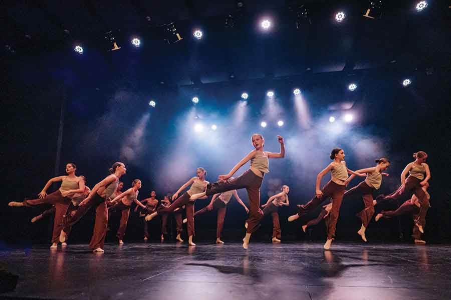 The junior contemporary group performs The Cave during the recital, showcasing expressive movement and storytelling through dance