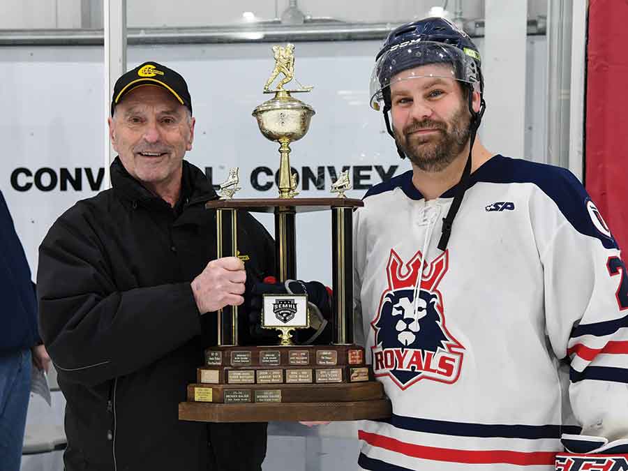 Carman Beavers former president and general manager Dennis Young presents Winkler’s Aaron Lewadniuk with the SEMHL West End Tire Top Scorer Award prior to Winkler’s 4-3 playoff victory over Notre Dame on Feb. 21