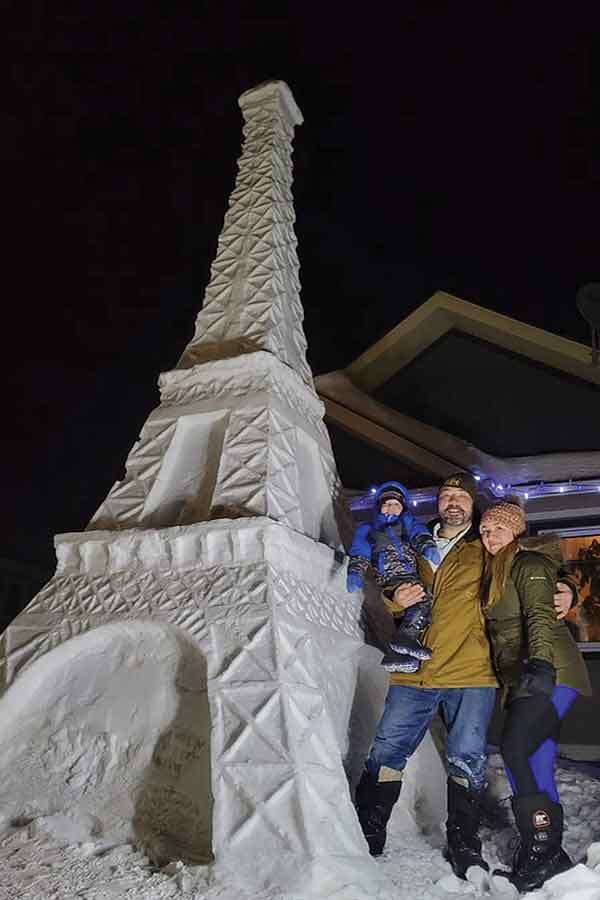 LeSage poses with his wife, Yansiri Alejandro Gonzalez, and their son in front of his snow sculpture recreating the Eiffel Tower in Paris, France