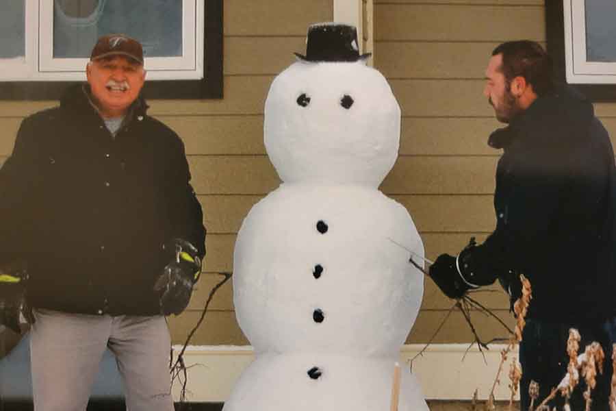 LeSage and his father, Larry, pose with the first snow sculpture they created in Gillam eight years ago