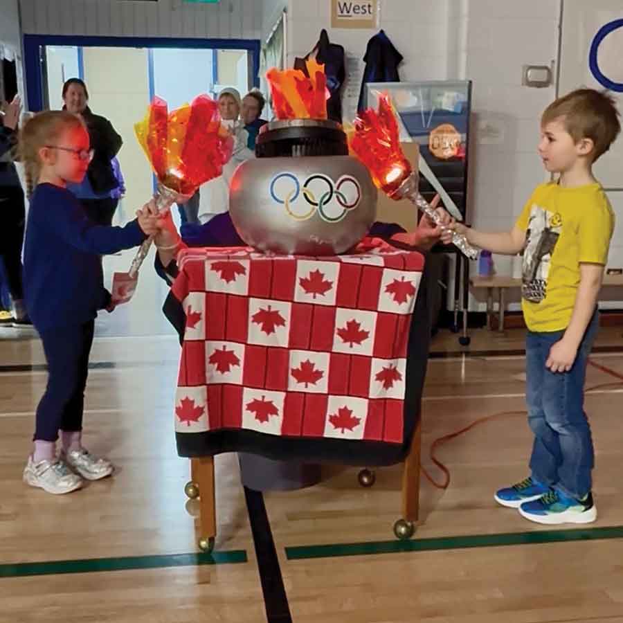 Two students light the Olympic cauldron together during the opening ceremonies of École Carman Elementary School’s Olympic Games on Feb. 26 in Carman. The lighting of the cauldron marked the official start of the two-day event, which featured a variety of winter-themed activities and friendly competition for students throughout the school