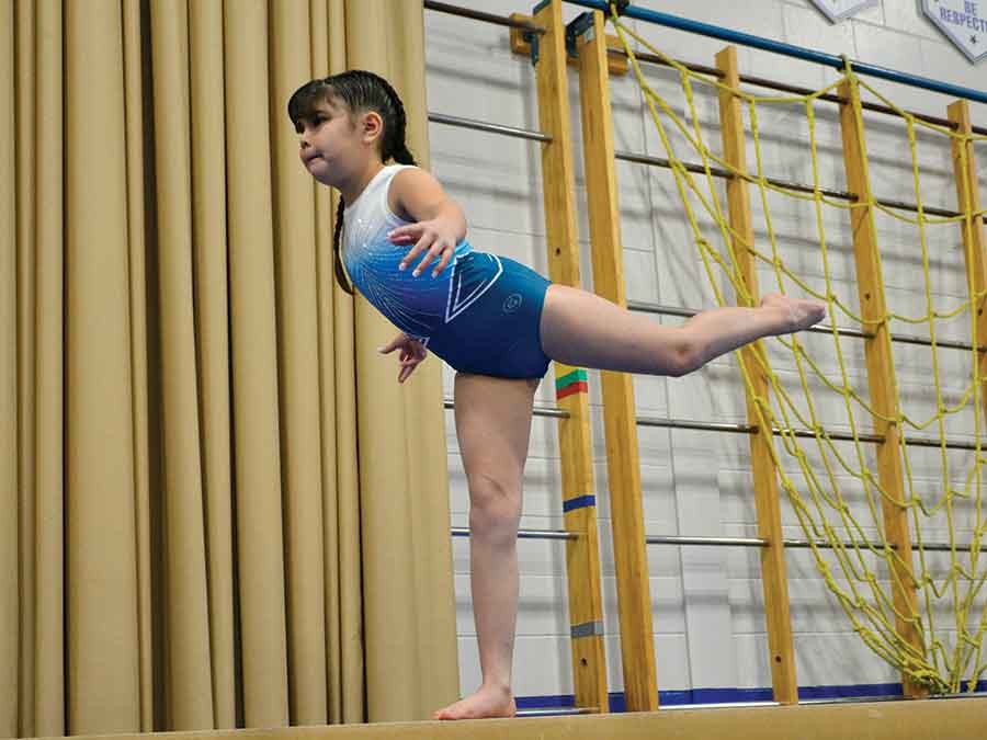 Kennasyn Geisler stikes an arabesque on beam