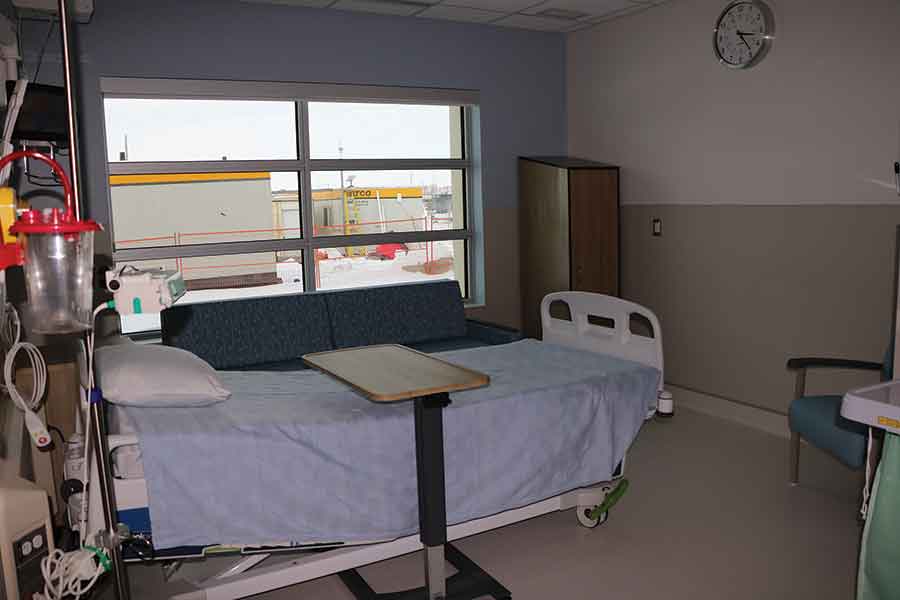 BTHC director of health services Joel Nelson leads a tour of the new inpatient unit, which features 24 acute care and palliative care beds (right). The two-storey building also includes both public and private gathering spaces for family and other visitors
