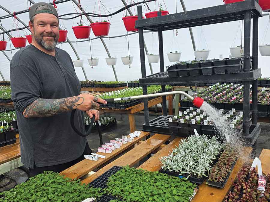 Rayme Thomson waters plants inside the greenhouse at Georgetown Acres & Interlake Garden Centre as the couple prepares for the upcoming spring opening