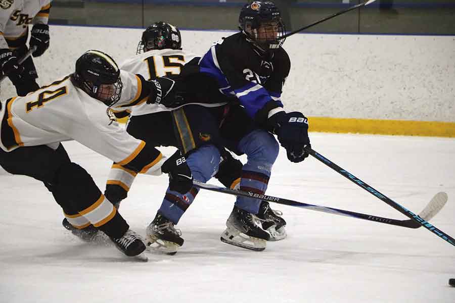 Selkirk Royals’ Jace Guevarra (right) battles through traffic as two Sanford Sabres defenders attempt to tie him up