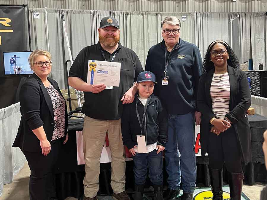 Tribune Photo Submitted Lundar-area inventor Kurtis Howardson, second from left, poses with his eight-year-old son, Harlon, after accepting a runner-up Farm Safety Award for The Drawhand during the Innovation Showcase at Manitoba Ag Days 2026 in Brandon
