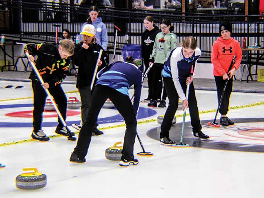 Team Banana Bunch sweeps the ice during action at the Gimli Junior Funspiel