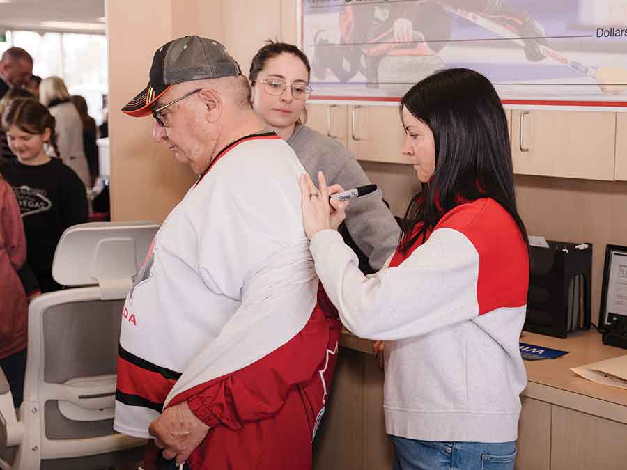 Kerri Einarson signs an autograph for a fan during her homecoming celebration