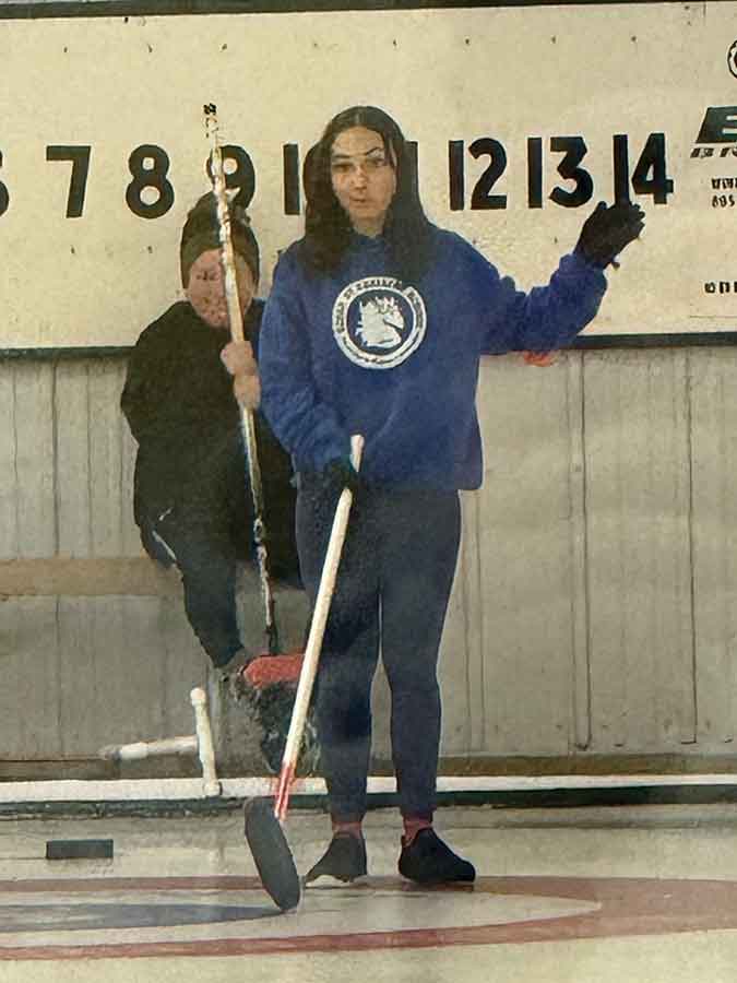 Mackenzie Gaudrault, 13, curls with the Marquette Curling Club. One of her coaches, Ed Campbell, added a flashlight to a curling stick to help her see the end of the rink