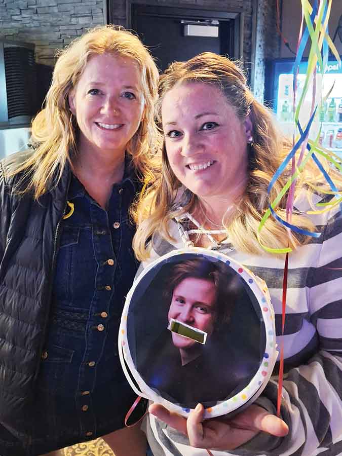 Organizers Krista Edkins, left, and Nikki Mattson stand with the donation bucket that raised $1,008