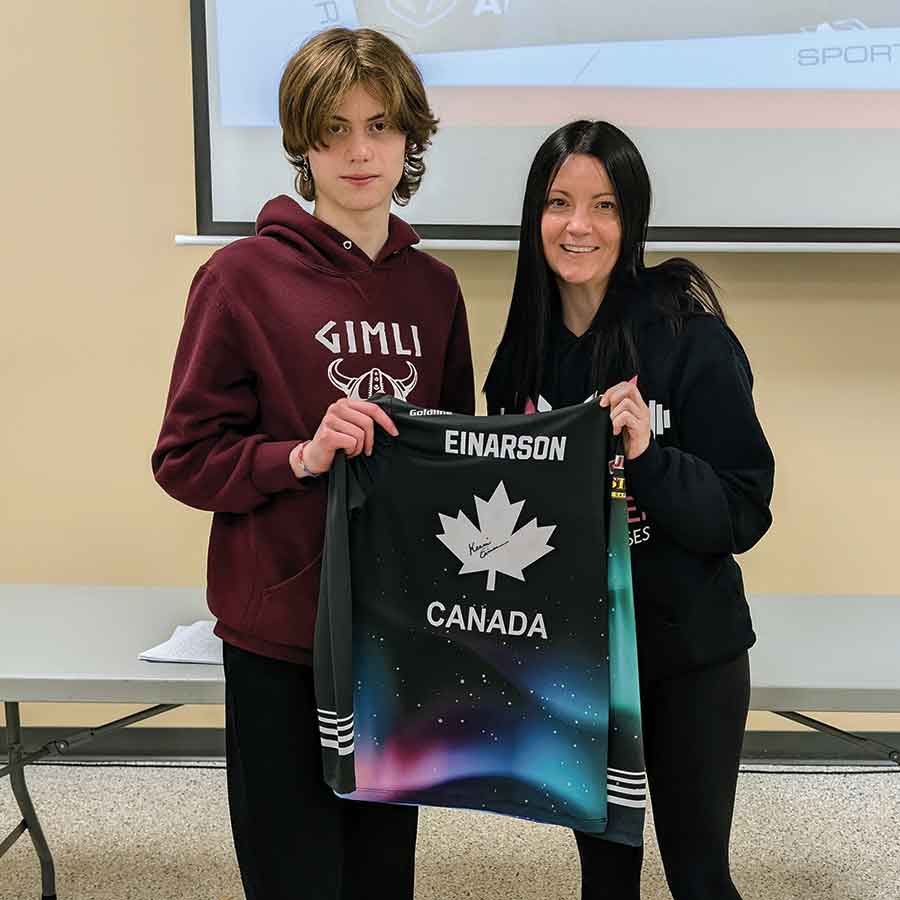Kerri Einarson, right, presents a signed jersey to Alice Boaz, whose name was drawn at random during the Junior Funspiel