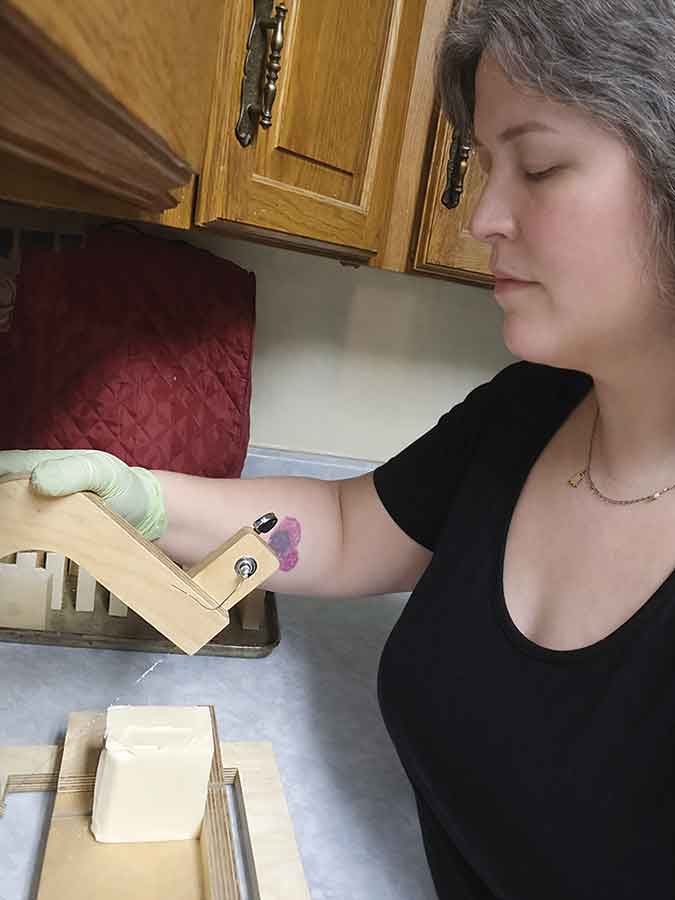 Ducked Up Farm owner Tara Toole cuts a block of goat’s milk soap