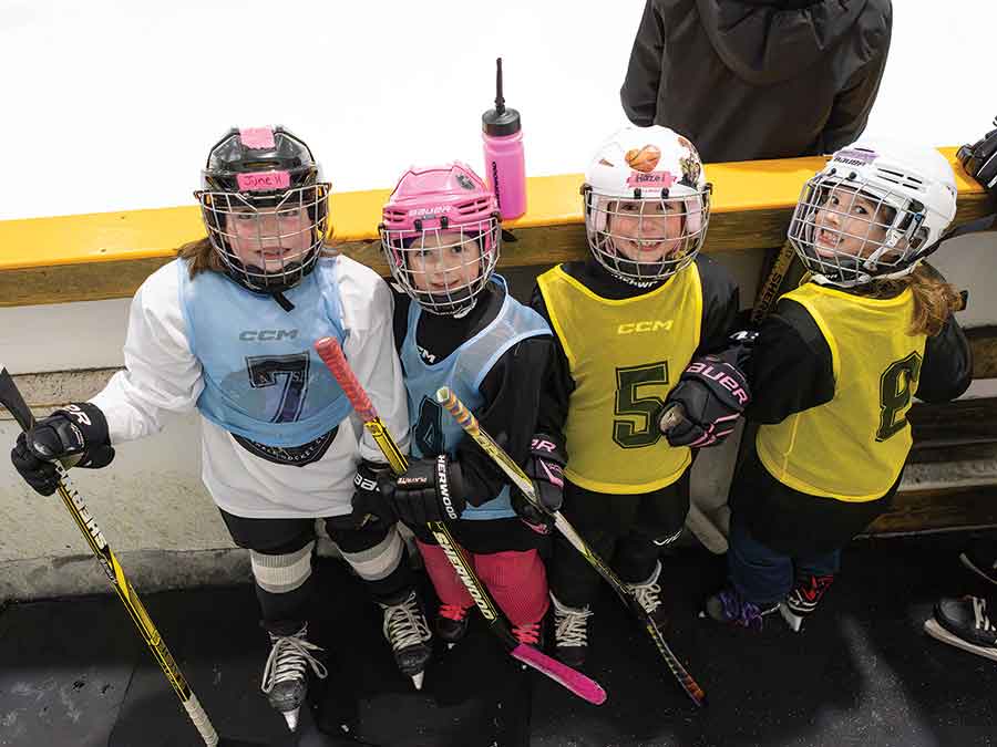 From left, June Holtmann, Kate Elskamp, Hazel Perron and Acadia Goodchild wait their turn to take the ice for a scrimmage