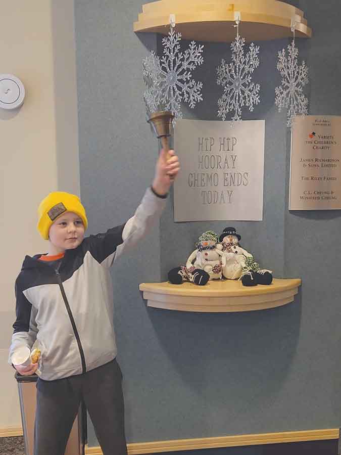 Kwintyn Dziedzic rings the bell marking the end of his cancer treatment