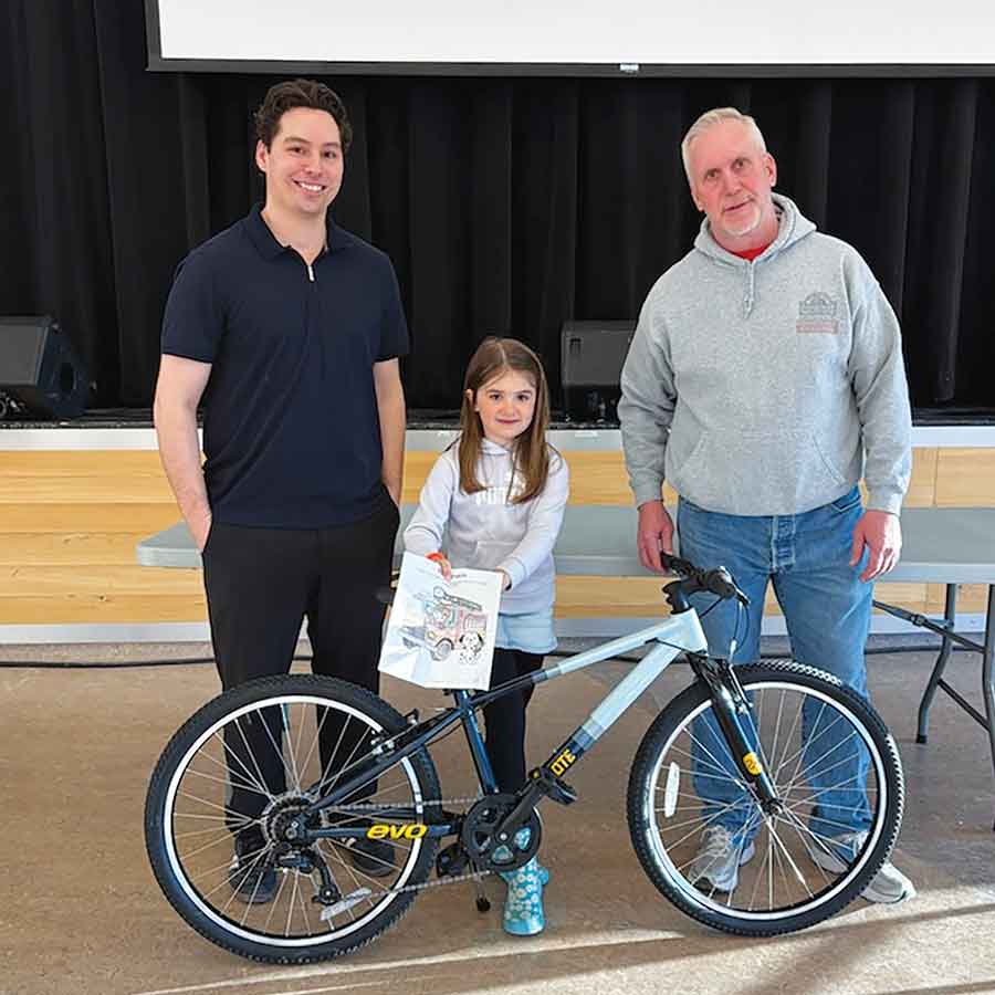 Stonewall rec director Kyle Andrade and Stonewall’s emergency coordinator Dennis Peterson present Cyane Henry with a new bicycle after she was named the winner of the colouring contest