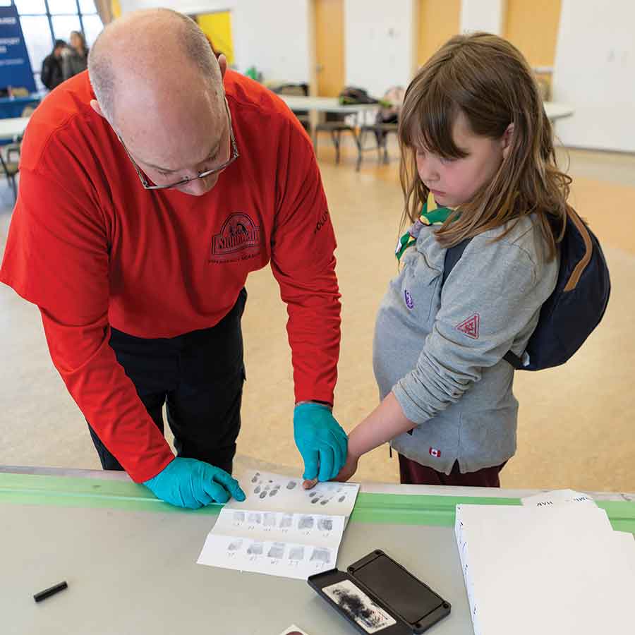 Winnipeg Police Forensics Unit Sgt. Chris McLean fingerprints Ali McGimpsey. Right photo: