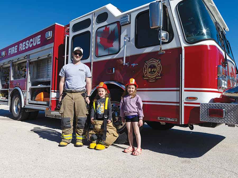 Future kindergarten student Raelynn Rance and her sister Rebecca pose with Stonewall-Rockwood firefighter Quin Arsenault