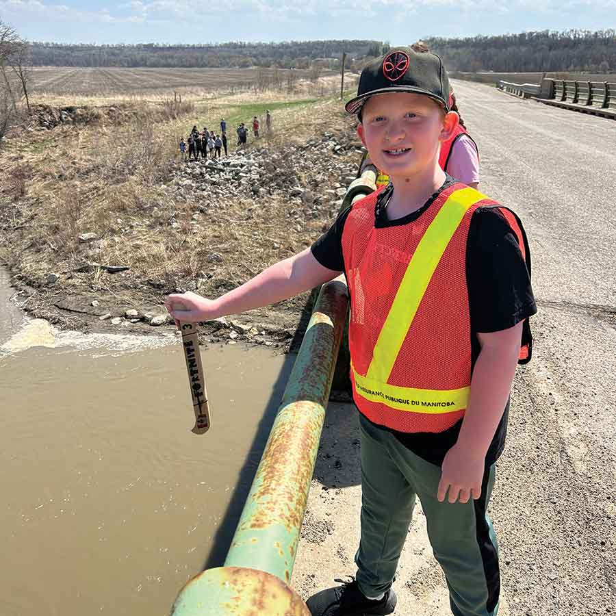 Two students from Treherne Elementary School drop their canoes, they helped decorate through the River of Dreams program, into the river
