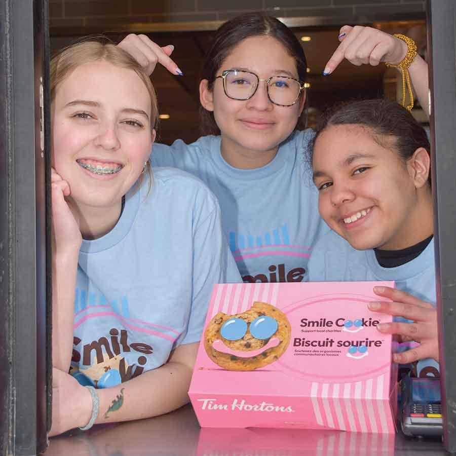 Altona Soccer players Maria Toledo, Elena Molina,  and Scarlett Broadfoot man the drive-thru at Altona’s TIm Hortons for Smile Cookie Week