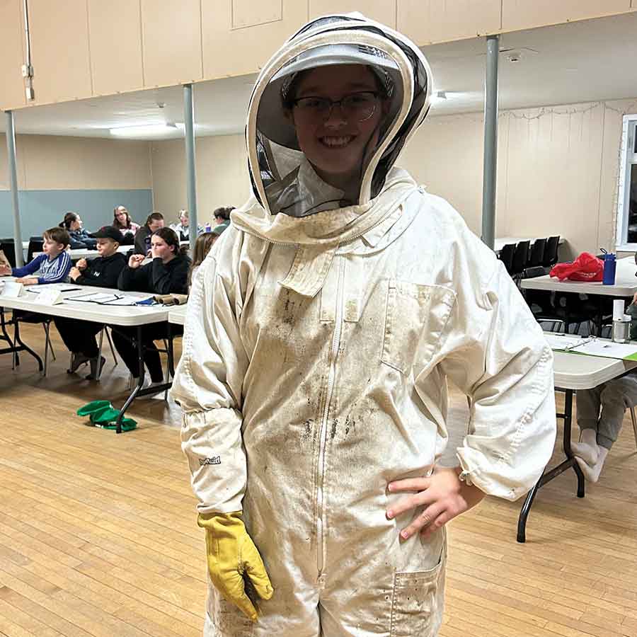 Melodie Versavel suits up in protective beekeeping gear