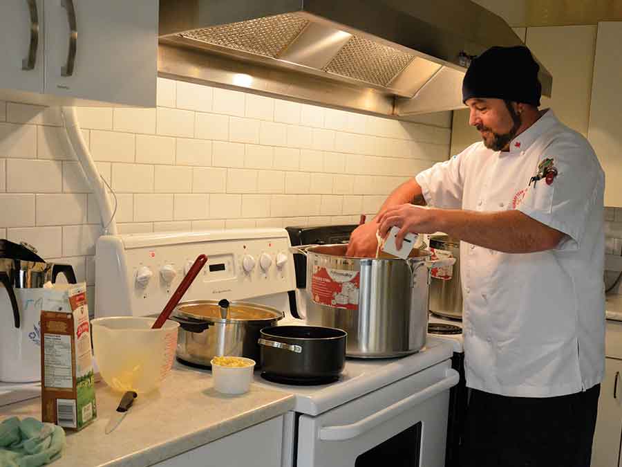 Paul Augst(left) and Joshua Hogan earned the Nello Altomare Award for Excellence in School Nutrition. Below: Hogan making food for the nutrition program back when it first started