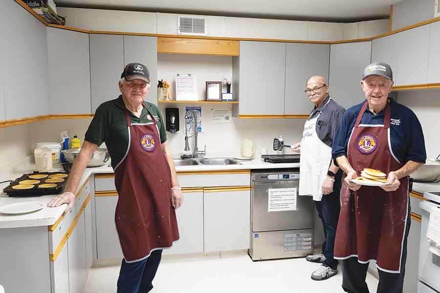 Lions members from left: Mel Harrison, Len Kolenich and Wally Finnbogason were busy in the kitchen making pancakes for hikers and guests