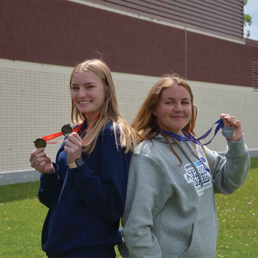 Gimli High School’s Jencie Henry (left) and Jerika Samborski celebrate their podium finishes at the Manitoba Provincial Track & Field Championships. Henry captured gold medals in varsity girls discus and shot put, while Samborski earned silver in junior varsity girls discus