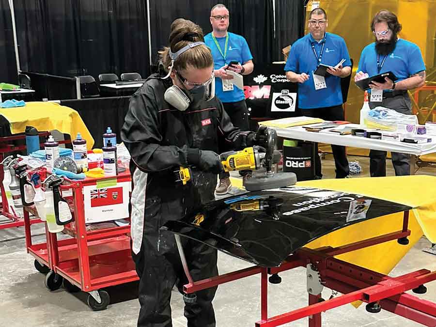 Cassandra Foy polishes imperfections from the surface of a vehicle hood as part of the refinishing process