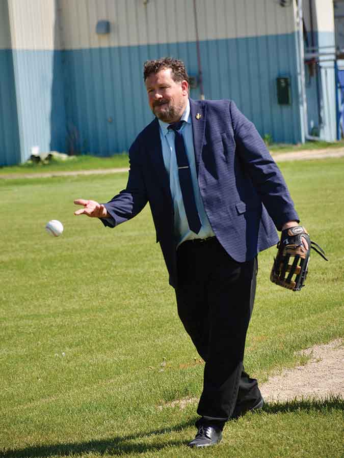 Minister Simard tosses a baseball with local youth following the announcement of $1.2 million in provincial funding for the outdoor sports complex