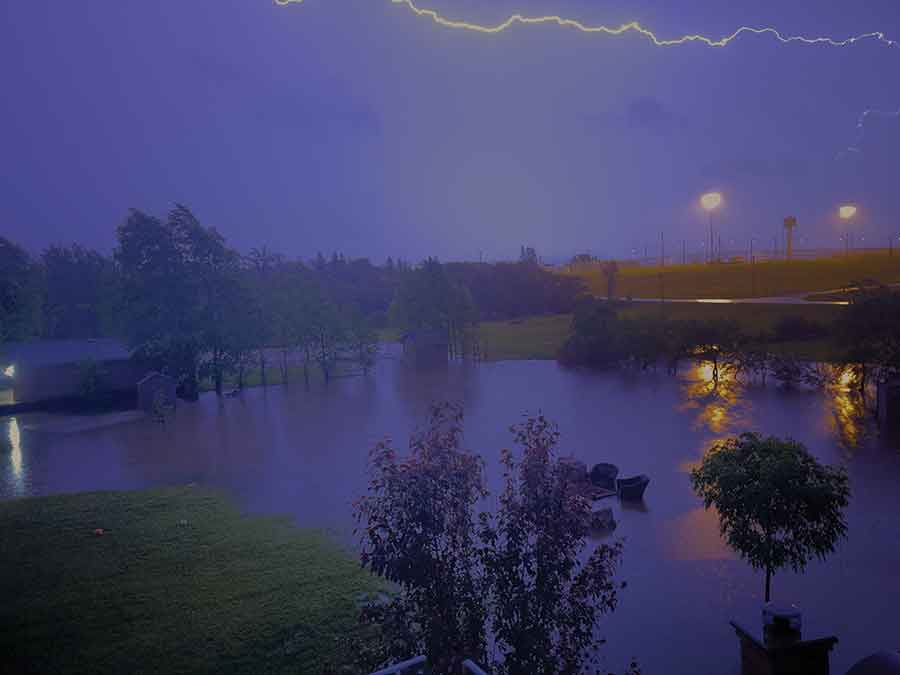 Lightning illuminated ominous storm clouds as a powerful weather system moved into the area, bringing torrential rainfall and widespread flooding
