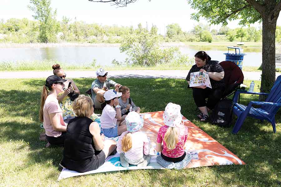 Pictured clockwise from top, families were encouraged to choose a book to take home. Lillian Klausen read in French to families. Const. Sahota read a story about inclusion and acceptance