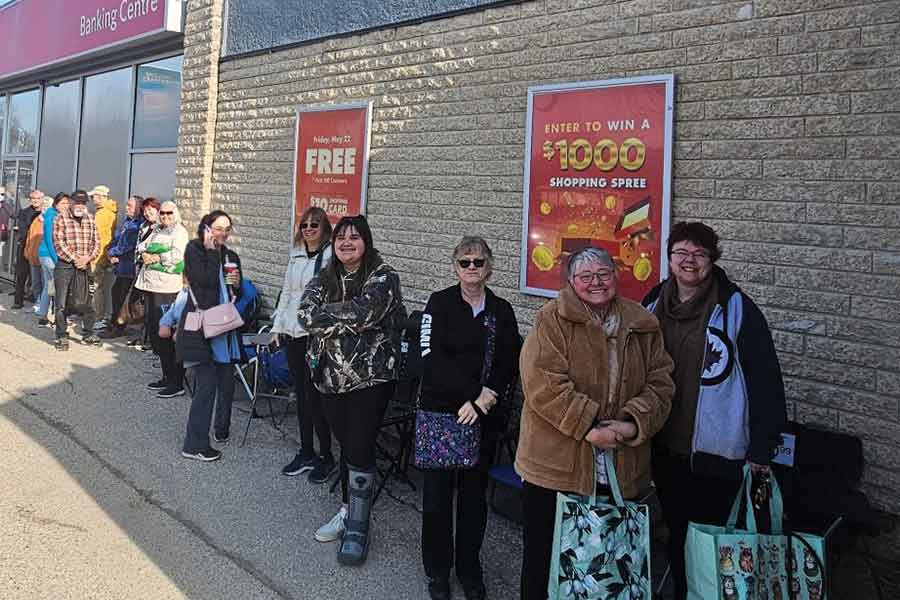 Customers line up outside during opening-day promotions, where the first 100 received a $10 shopping card and a laundry basket
