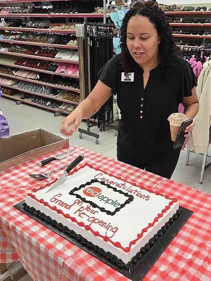 Store manager Tamara cuts the cake