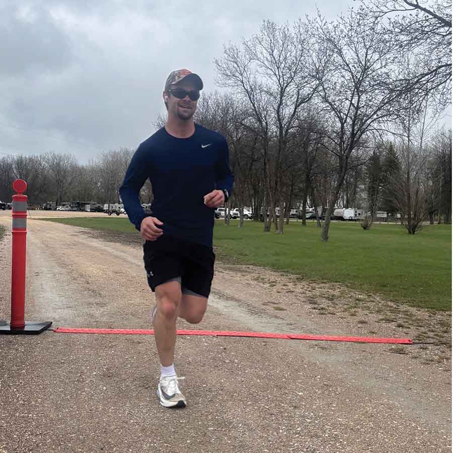 Jordan Simko crosses the finish line to claim first place in the men’s five-kilometre division