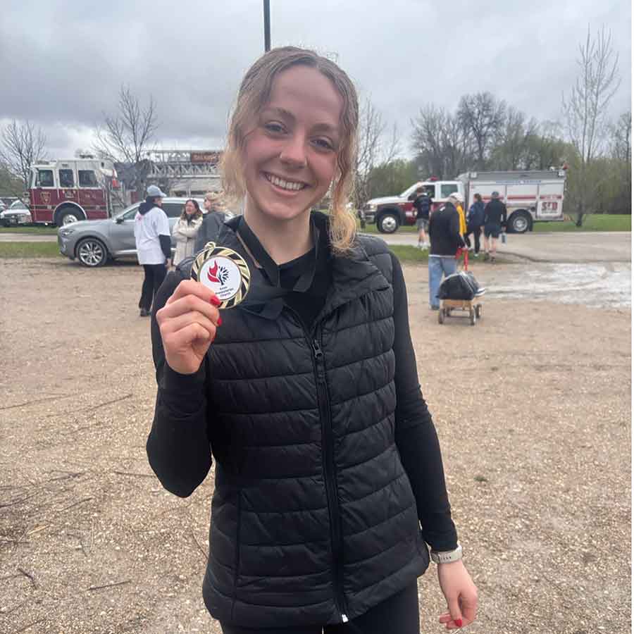 Rachel Winzoski poses with her medal after placing second in the women’s five-kilometre division