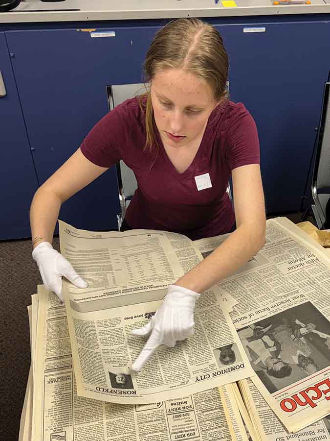 Gr. 10 student Justina Jansen pores through old community newspapers at the Altona Archives. Through a partnership with Regional Connections Immigrant Services, she and other newcomer students have been helping the archives with their preservation work