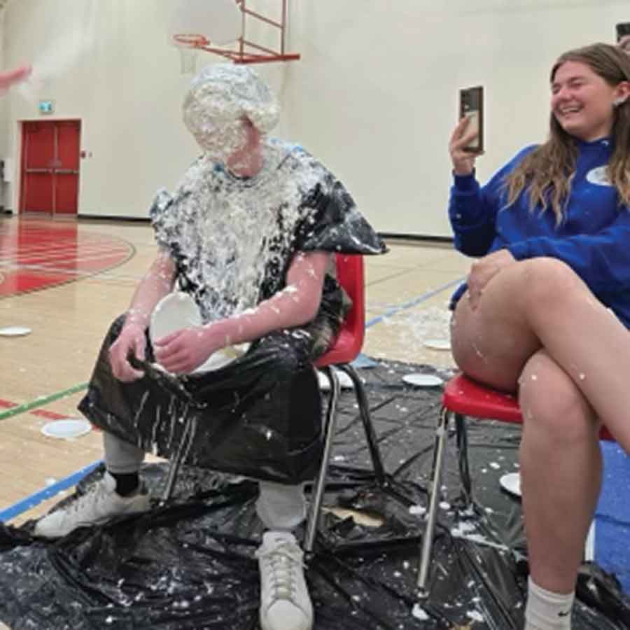 Kingston Lowe, a Grade 12 student, takes part in the Pie in the Face fundraiser on May 14, receiving more than 20 pies